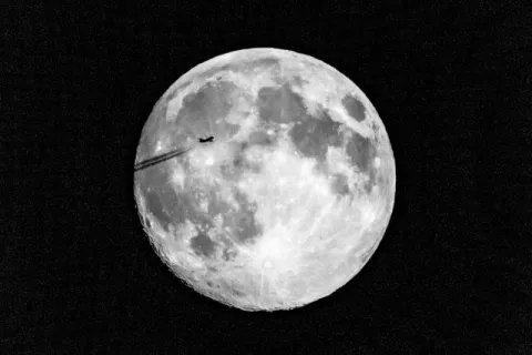 Plane in front of the super moon