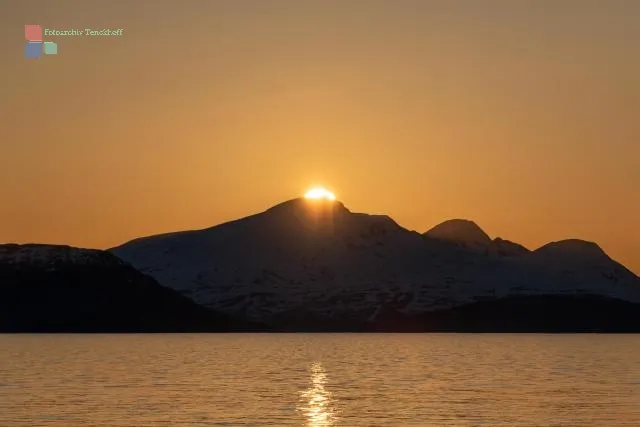 Die Mitternachtssonne über der Insel Reinøya im Ullsfjord in Norwegen