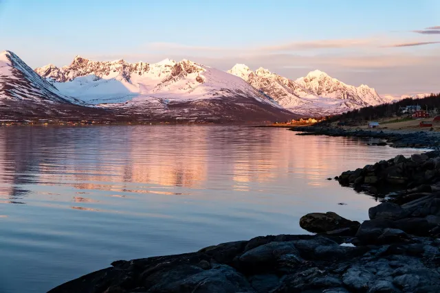 The reflection of the Lyngen Alps in Sør-Lenangen Bay and the now golden shimmering village of Lenangsøyra.